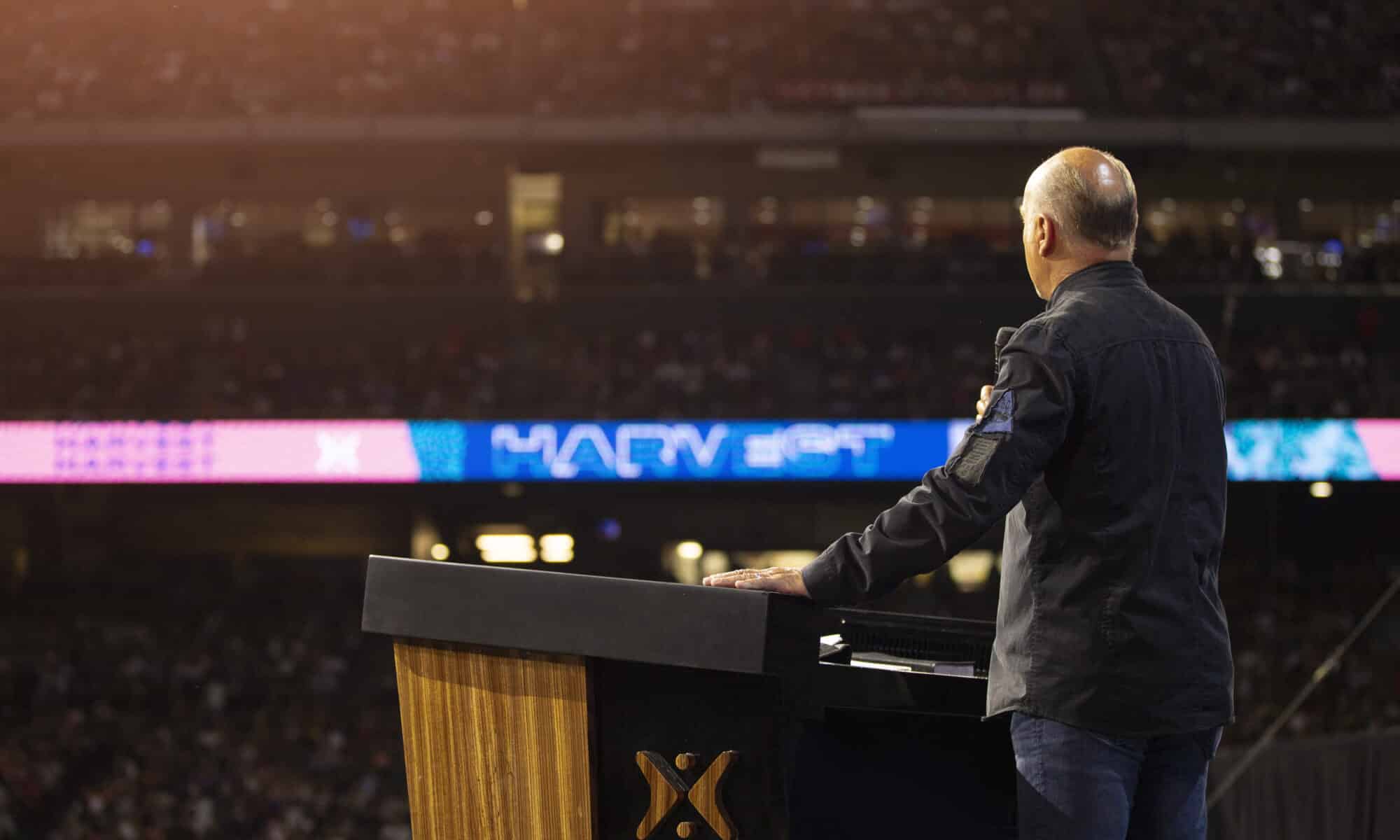 Greg Laurie standing in front of audience at Angel Stadium during a Harvest Crusade