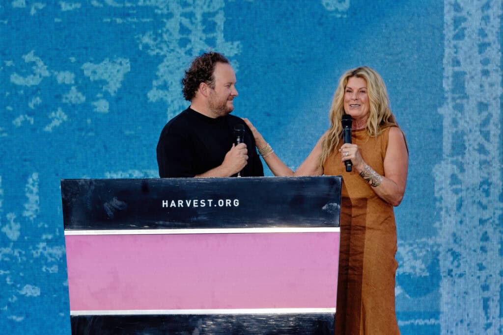 Jonathan Laurie and Cathe Laurie speaking together on stage at the 2024 Harvest Crusade