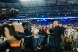 pastor greg laurie on the field of angel stadium with audience making professions of faith