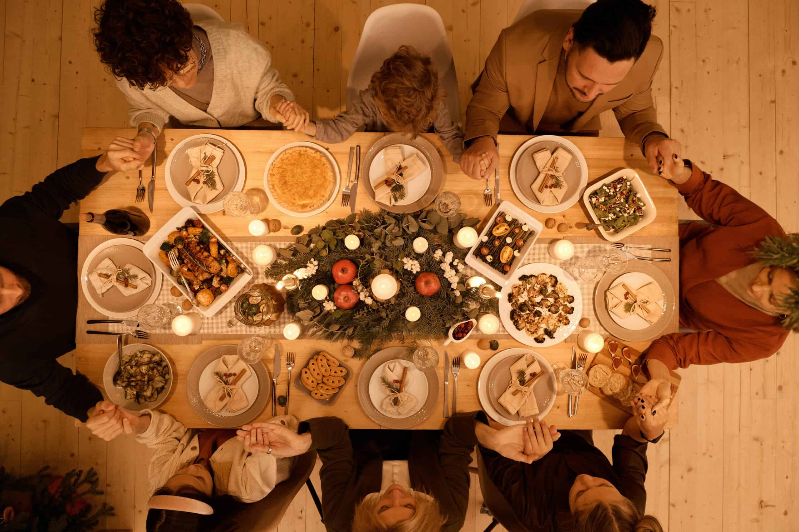 family praying to God at Thanksgiving dinner.